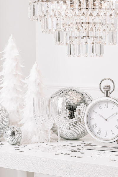 New Year’s Eve decorations with clock at midnight, champagne glasses and disco ball