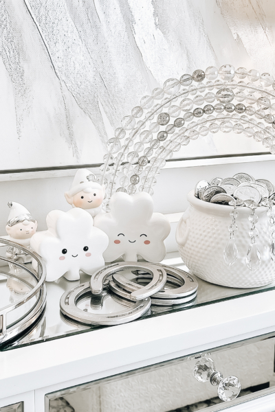 St. Patrick’s Day decorations with shamrocks, pot of gold coins and rainbow beads on shelf